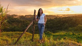 Catalina Vélezová stojí v poli zalitém zapadajícím sluncem